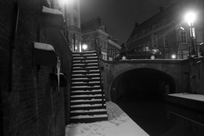 883880 Gezicht op de Pausdambrug over de Nieuwegracht te Utrecht, tijdens winterse omstandigheden, bij nacht.